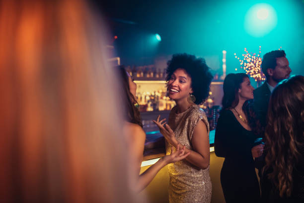 I wandered if you are going to make it to the party Cropped shot of two female friends talking in the club. work party stock pictures, royalty-free photos & images