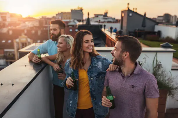 Cropped shot of four friends hanging out on a rooftop