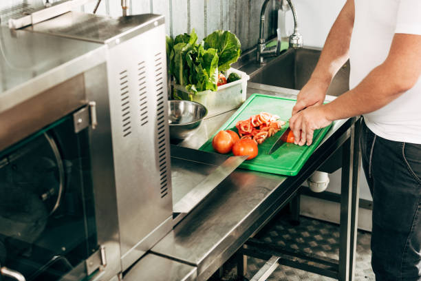istock partial view of cook cutting tomatoes on chopping board 1171958680