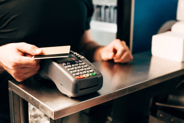 istock cropped view of man with credit card using payment terminal 1171958684