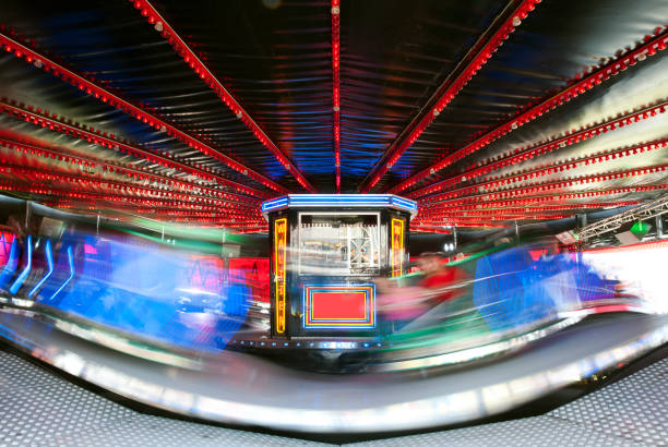 Waltzer at speed. Fairground and amusement park rides offer both pleasure and pain, by attempting to scare or frighten the passenger with speed, extreme movements and disorientation that tests and challenges personal endurance, England, UK