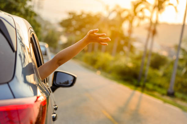 Happy woman Driving on Country Road into the Sunset stock photo