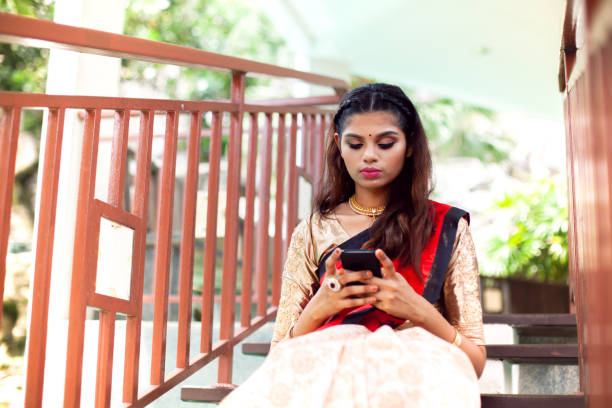 istock Young Indian woman in saree (sari) using smartphone 1171960383