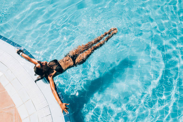 młoda czarna kobieta na basenie ośrodka - resort swimming pool swimming swimming pool women zdjęcia i obrazy z banku zdjęć