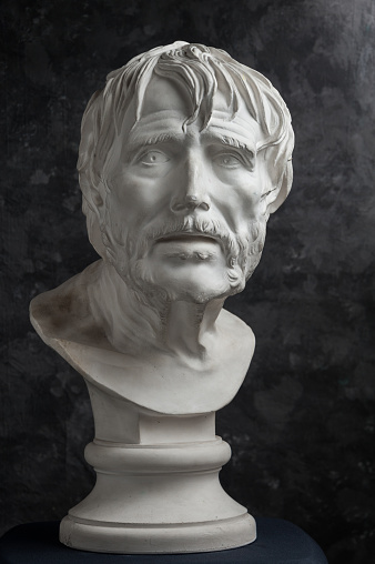 White gypsum copy of ancient statue of Lucius Seneca head for artists on a dark textured background. Seneca 4 BC-65 AD Roman stoic philosopher, statesman and tutor to the future Emperor Nero.