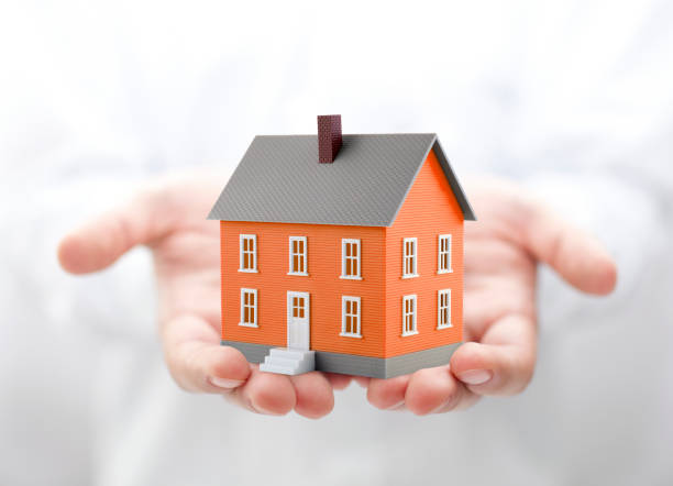 istock Orange house miniature in hands 1171974766