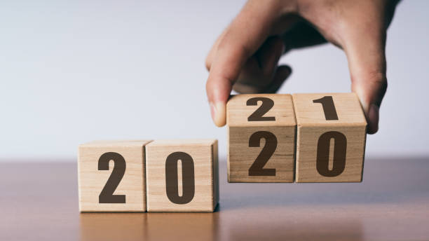 New year 2020 change to 2021 concept, hand change wooden cubes stock photo