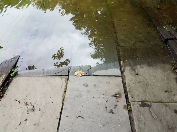 istock grey stone tiles leading down to water flooded area 1171976622