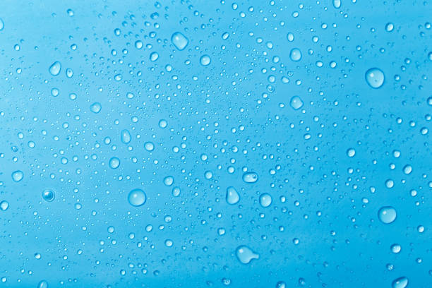 Rain droplets on blue glass background, Water drops on blue glass.