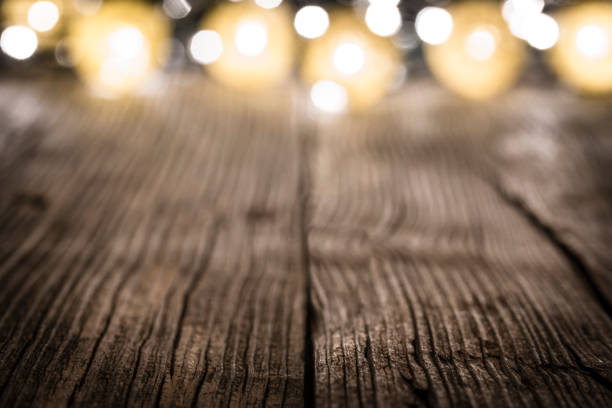 istock Empty rustic wooden table with blurred Christmas lights at background 1171982793