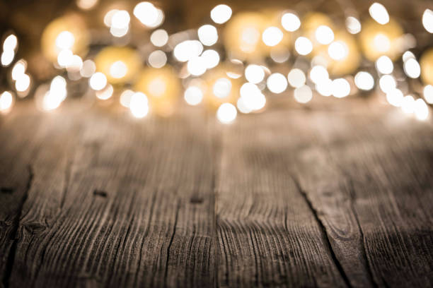 istock Empty rustic wooden table with blurred Christmas lights at background 1171984928