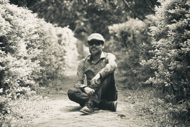 istock Man sitting around a walkway of a park 1171985763