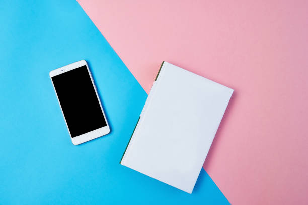 Mockup Flat lay composition with smartphone and notepad on a blue and pink background. stock photo