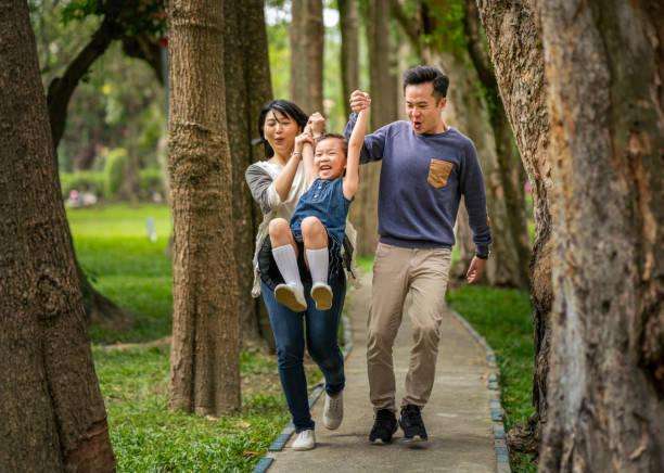 istock Parents lifting daughter while walking at park 1171992777