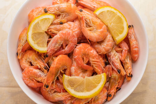 istock tasty boiled tiger prawns with lemon slices on a white plate 1171995680