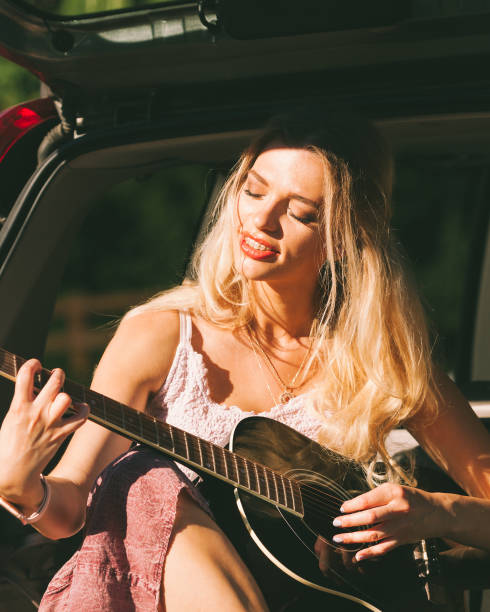 istock Girl with guitar on hatchback car 1172012427