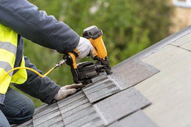 operaio che utilizza pistola pneumatica per unghie installare piastrelle sul tetto di una nuova casa in costruzione - repairing foto e immagini stock