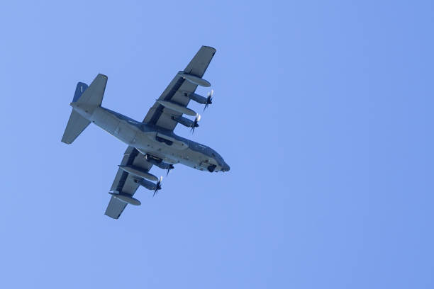 istock grey military transport plane fly on blue sky background 1172016025