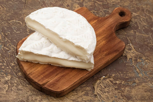 istock Soft cheese with white mold on a cutting board, with vegetables. Snack to wine 1172020769