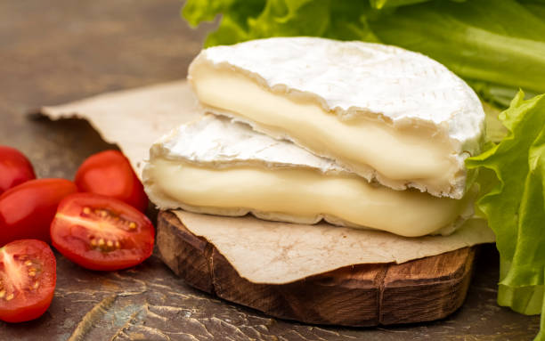 istock Two pieces of cheese with white mold on the cutting board. brie cheese 1172020770