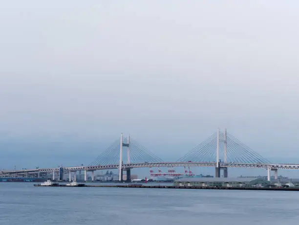 Yokohama, Kanagawa, Japan: View of Yokohama Bay Bridge and Yokohama sea port with warehouses at dusk.