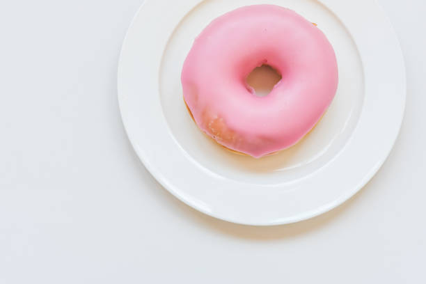 istock Pink donut on white plate from above 1172044192