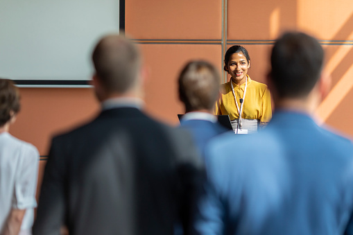 An Indian female presenter interacting with the audience at a business presentation