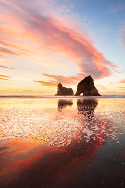 nuvole rosse al tramonto invernale della nuova zelanda - golden bay foto e immagini stock