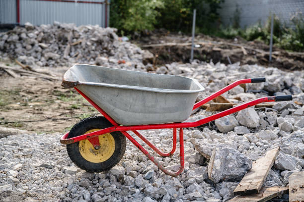 wheelbarrow on the background of construction debris consisting of concrete and old boards