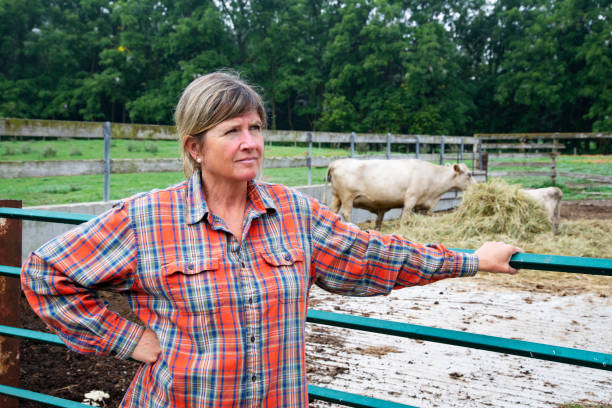 istock A female farmer outside of cattle pen.  She has a pensive expression. 1172049911