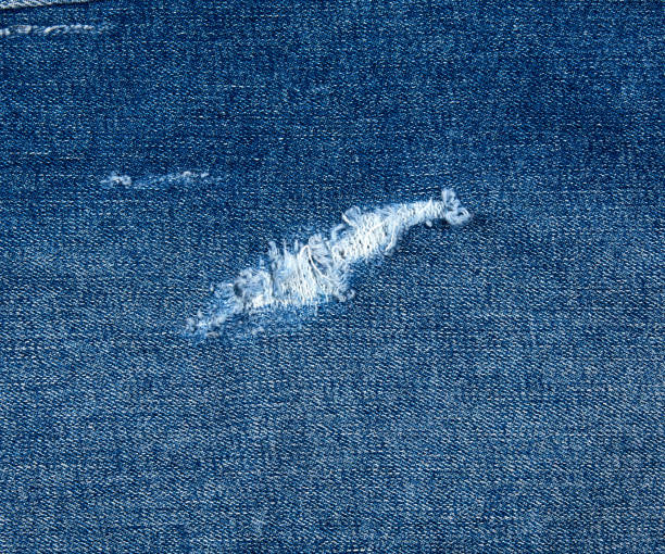 istock fragment of blue jeans fabric with a hole, full frame 1172050767
