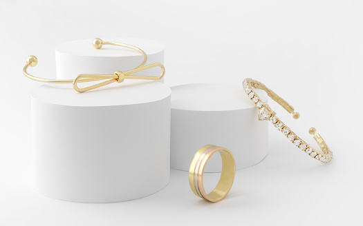 Golden girl accessories two golden bracelets and ring on white cylinders