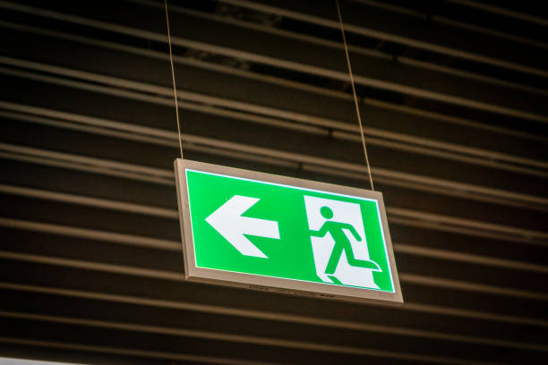 istock Emergency fire exit sign glowing green in the blacked out background 1172051901