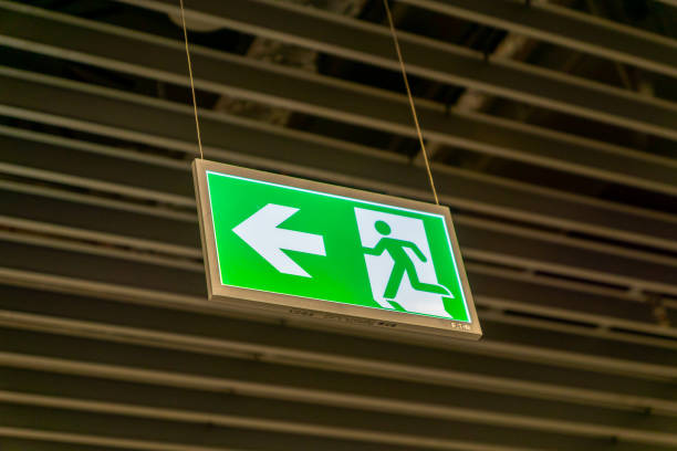 istock Emergency fire exit sign glowing green in the blacked out background 1172051918