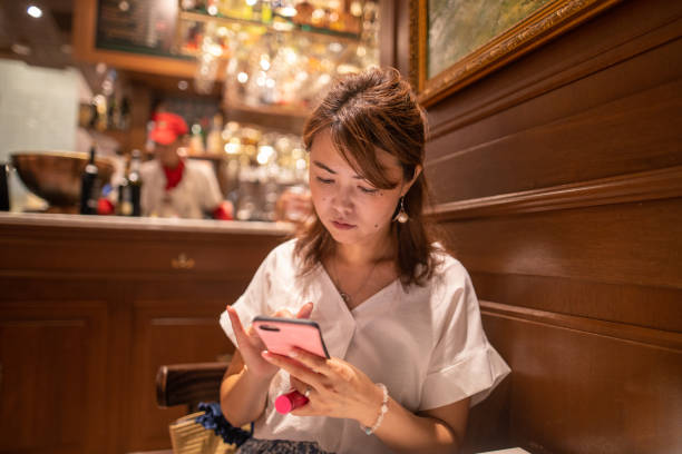 istock Japanese woman typing message in cafe at night 1172061633