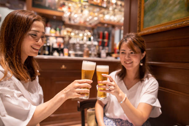 Business women drinking beer at bar after work