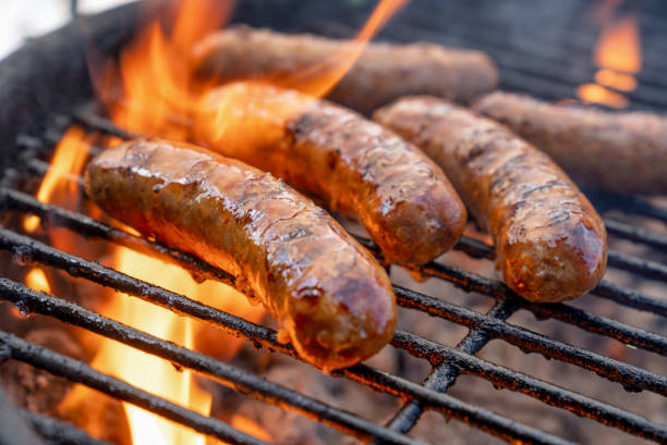 caliente delicioso bratwurst o brats en una parrilla ardiente casi listo para comer - sausage bratwurst barbecue grill barbecue fotografías e imágenes de stock