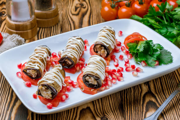 istock Eggplant rolls stuffed with nuts on wooden table 1172064743