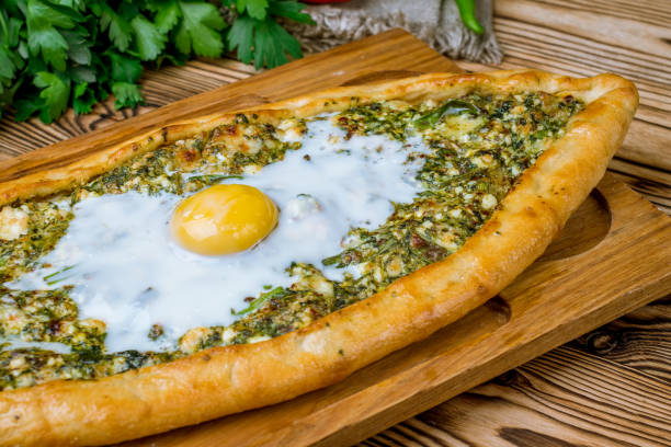 istock Turkish pide with spinach and egg on wooden table 1172065854