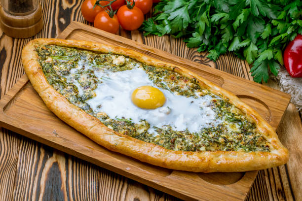 istock Turkish pide with spinach and egg on wooden table 1172066223
