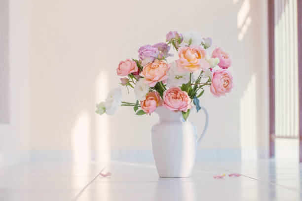 Bunch of roses laying on an old book with textured woven surface. Romantic wedding stock photo. Macro. Close up.