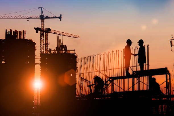 istock Silhouette Two engineers consult and inspect high-rise construction work over blurred industry background with Light fair.Create from multiple reference images together 1172073061