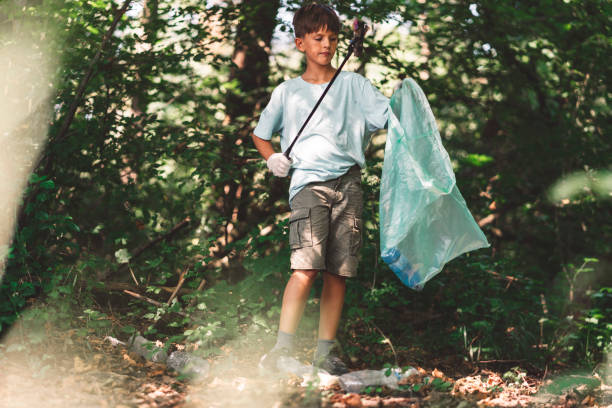 istock Young volunteer picking up trash in the forest 1172073117