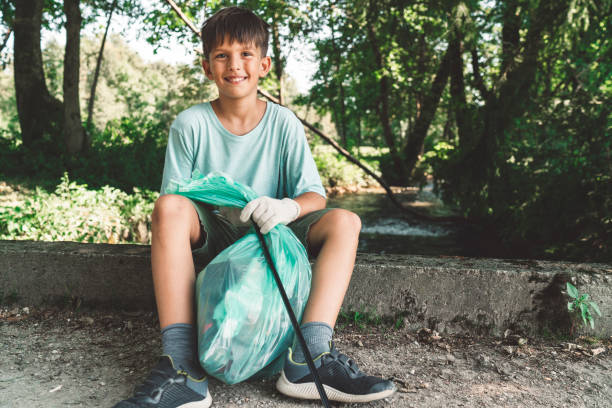 istock Happy young boy with a garbage bag - Cleaning the environment 1172073124