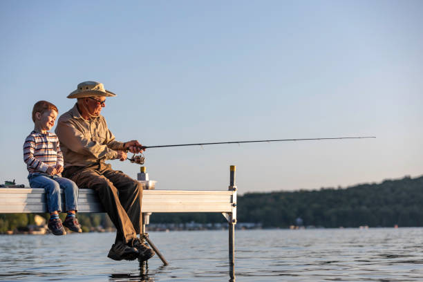 grandfather and grandson fishing at sunset in summer - 6720 imagens e fotografias de stock