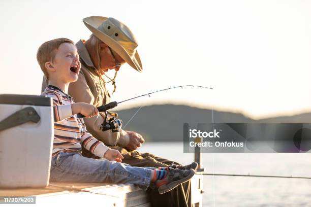 Großvater Und Enkel Angeln Bei Sonnenuntergang Im Sommer Stockfoto und mehr Bilder von Fischen