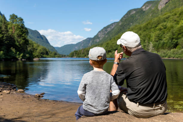 grandfather and grandson contemplating the lake and mountains in summer - 6720 imagens e fotografias de stock