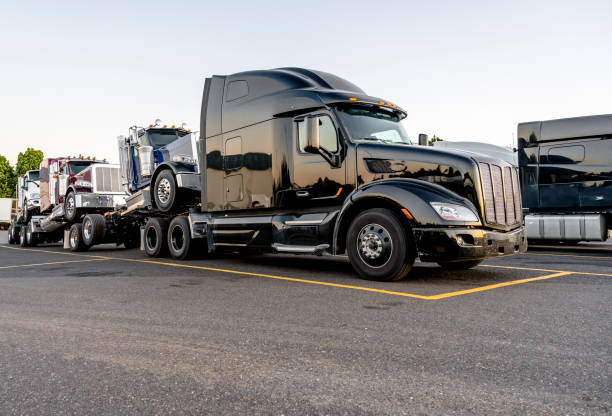 istock Black big rig powerful semi truck transporting coupled another semi tractors 1172081226