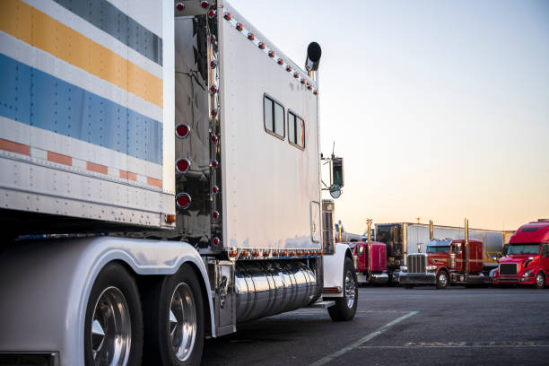 istock White big rig bonnet American make semi truck with long sleeping compartment standing on the truck stop opposite another semi trucks 1172084479
