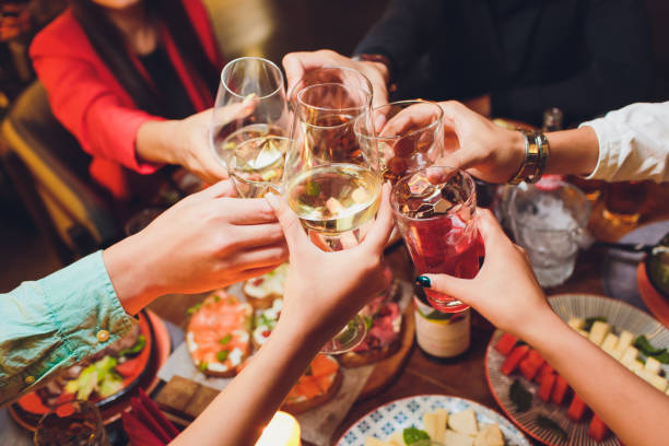 istock Human hands with glasses of red wine clinking them over served table. 1172084710